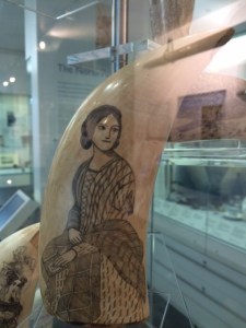 A woman in mid-Victorian dress with a plaid shawl.