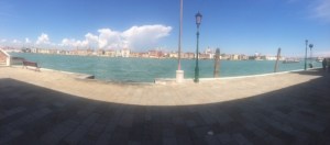 A panoramic view across the Giudecca Canal from the shadow of the loggia.
