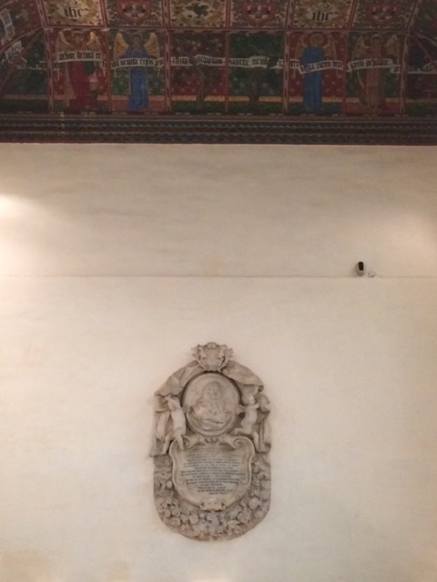 The memorial's height on the wall can be gauged from its distance from the ceiling, painted to a William Morris design in the nineteenth century.